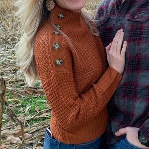 Burnt orange turtleneck sweater with unique button design